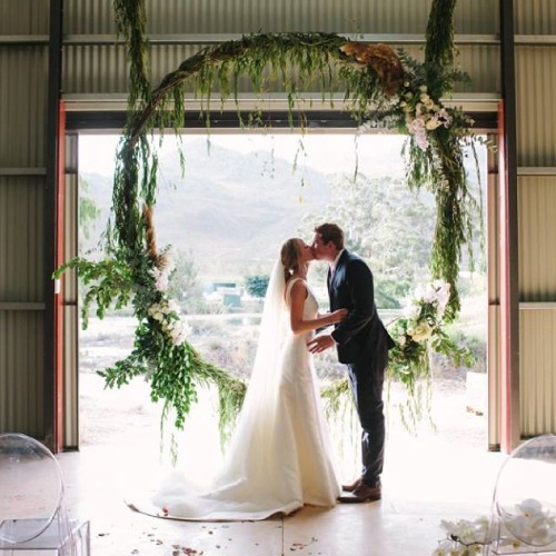 Newly married couple standing in the doorway of the Red Shed